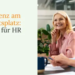 Zwei Frauen lachen im Büro. Der Text "Resilienz am Arbeitsplatz: Tipps für HR" und ein Buchsymbol sind links zu sehen.