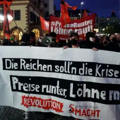 Demonstranten mit Banner "Die Reichen soll'n die Krise zahlen, Preise runter, Löhne rauf!" zeigen die politische polarisierung definition.