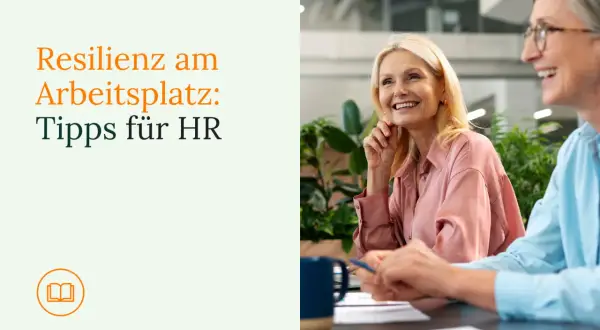 Zwei Frauen lachen im Büro. Der Text "Resilienz am Arbeitsplatz: Tipps für HR" und ein Buchsymbol sind links zu sehen.