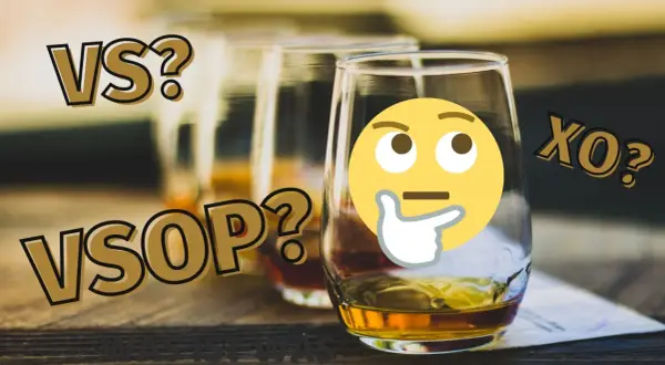 VS, VSOP, XO? Ein nachdenkliches Emoji fragt sich, was die VSOP Bedeutung ist. Mehrere Gläser mit bernsteinfarbener Flüssigkeit stehen bereit.