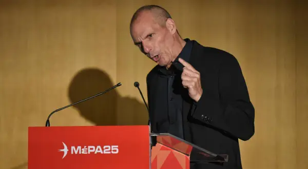 Mann spricht an Rednerpult mit "MÉPA25"-Logo. Seine Mimik deutet auf Kritik hin.