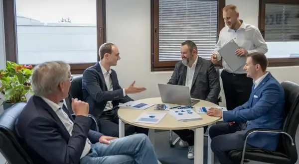 Geschäftsmänner diskutieren über Kennzahlen, wie z.B. die days payable outstanding deutsch, bei einem Meeting.