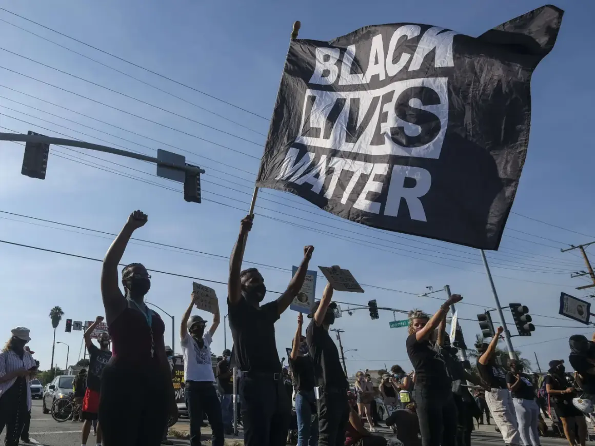 Menschen demonstrieren mit einer "Black Lives Matter"-Flagge. Die Bedeutung von Black Lives Matter ist die Forderung nach Gleichheit und Gerechtigkeit für Schwarze.