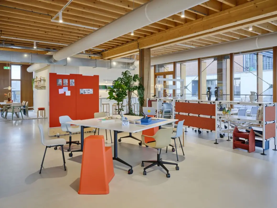 Helles, modernes new work office mit Holzbalkendecke, Besprechungstisch, Pflanzen und flexiblen Trennwänden.