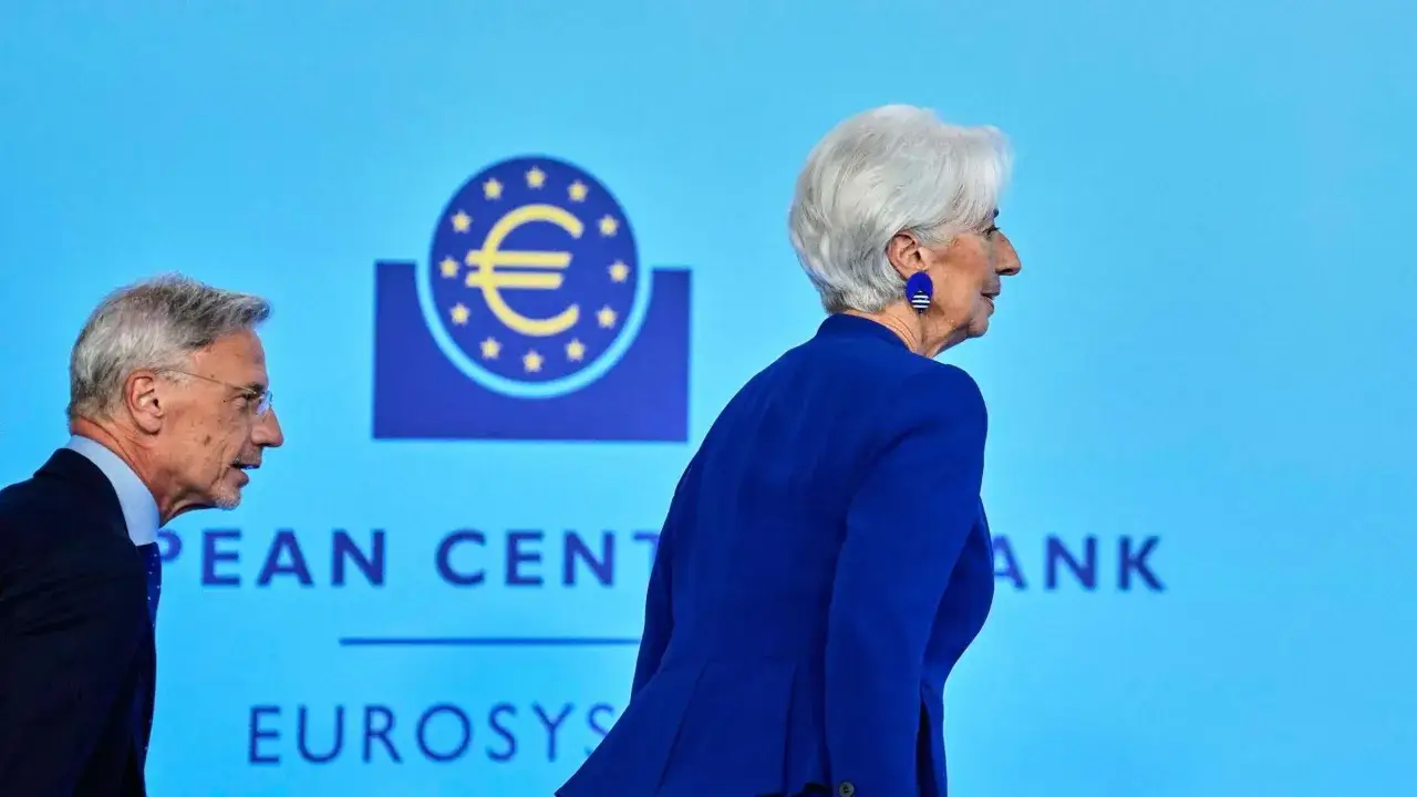 Zwei EZB-Ratsmitglieder, Christine Lagarde und ein Mann, gehen vor dem Logo der Europ&auml;ischen Zentralbank.