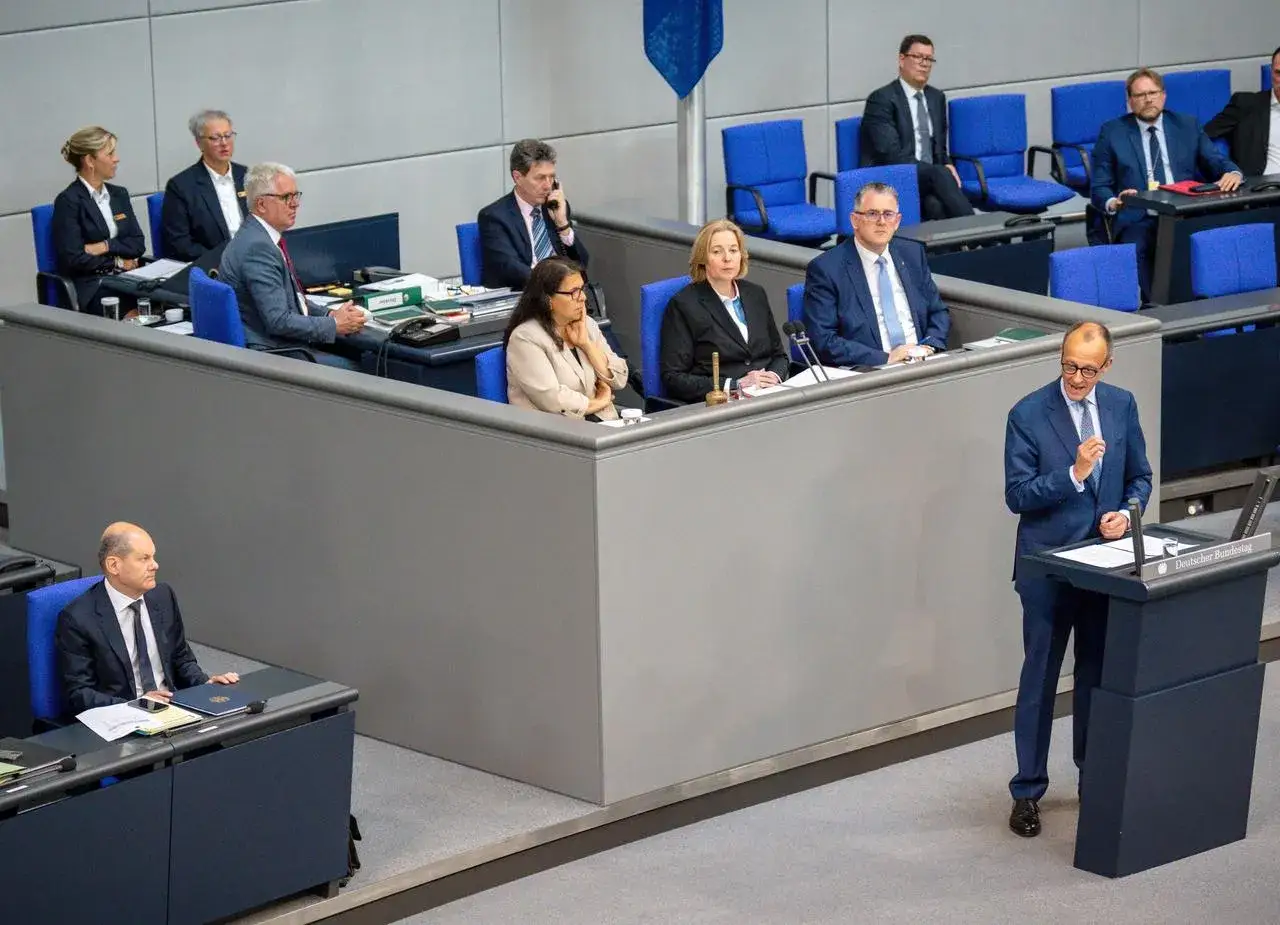 Ein Mann h&auml;lt eine Rede im Bundestag. Die politische Sprache ist hier lebendig, w&auml;hrend die Abgeordneten zuh&ouml;ren.