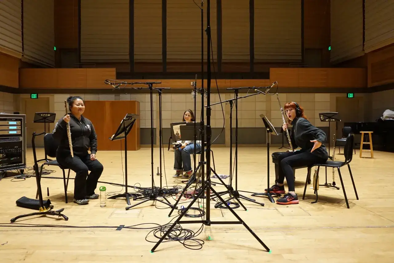 Drei Musikerinnen mit Fl&ouml;ten in einem Aufnahmestudio, bereit, mit Musik Geld zu verdienen.