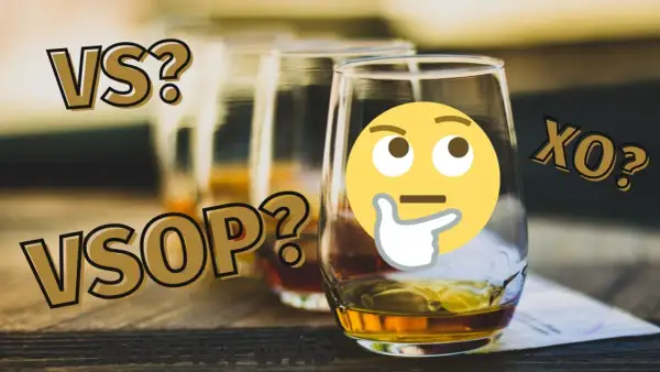 VS, VSOP, XO? Ein nachdenkliches Emoji fragt sich, was die VSOP Bedeutung ist. Mehrere Gläser mit bernsteinfarbener Flüssigkeit stehen bereit.