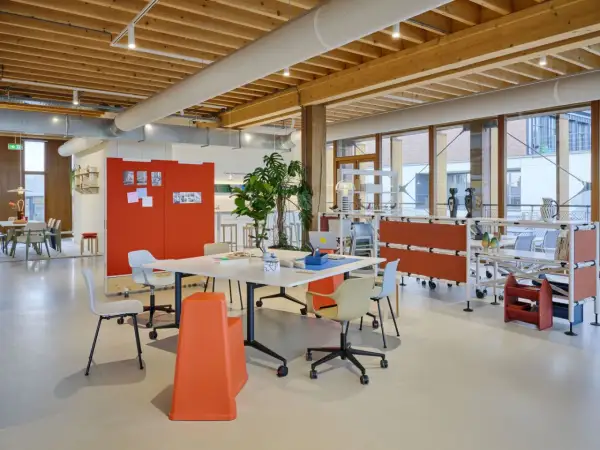 Helles, modernes new work office mit Holzbalkendecke, Besprechungstisch, Pflanzen und flexiblen Trennwänden.
